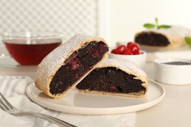 Photo of Delicious strudel with cherries and poppy seeds on white table, closeup