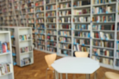 Blurred view of bookshelves and table in library