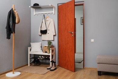 Modern hallway interior with shoe rack and wooden coat stand