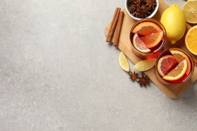 Aromatic punch drink and ingredients on light grey table, flat lay. Space for text