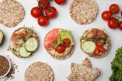 Set of crunchy buckwheat cakes with different ingredients on white background, flat lay