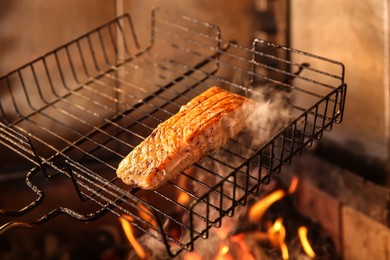 Grilling basket with salmon fillet in oven, closeup