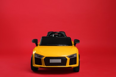 Child's electric toy car on red background