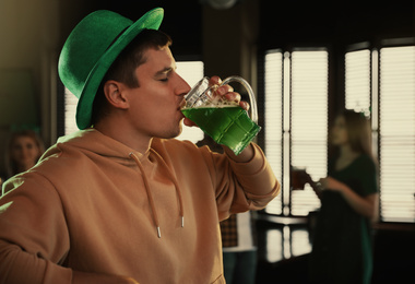 Man drinking green beer in pub. St. Patrick's Day celebration