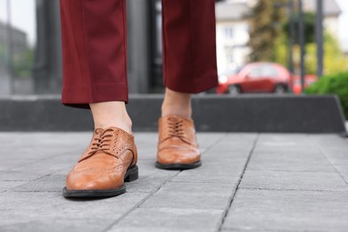 Photo of Woman in red pants and fashionable shoes walking on city street, closeup. Space for text