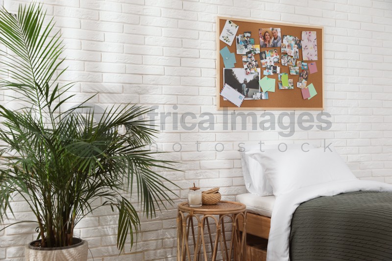 Stylish room interior with comfortable bed and vision board on wall