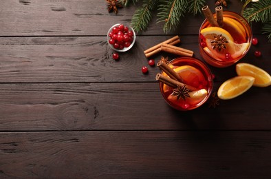 Delicious punch drink with cranberries, orange and spices on wooden table. flat lay. Space for text
