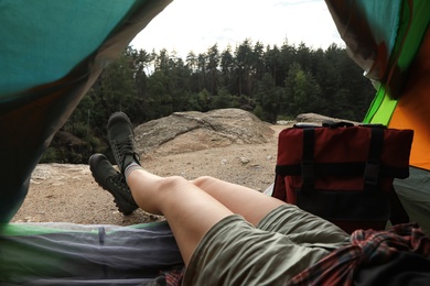 Young woman resting in camping tent, view from inside