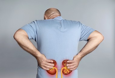 Image of Senior man suffering from kidney pain on light grey background