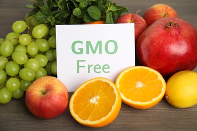 Tasty fresh GMO free products and paper card on wooden table