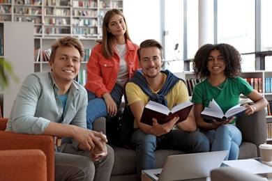 Group of young people studying at table in library