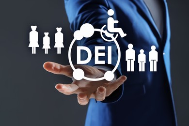 Concept of DEI - Diversity, Equality, Inclusion. Businessman showing virtual image of people, person with disability and abbreviation