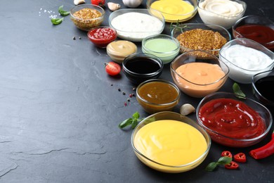 Photo of Many different sauces on black table, space for text