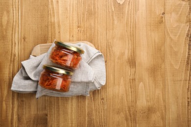 Delicious kimchi with Chinese cabbage on wooden table, flat lay. Space for text