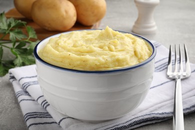Bowl of tasty mashed potatoes served on grey table, closeup