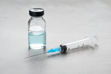 Syringe and vial on grey table. Medical anesthesia