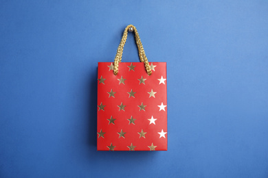 Red shopping paper bag with star pattern on blue background