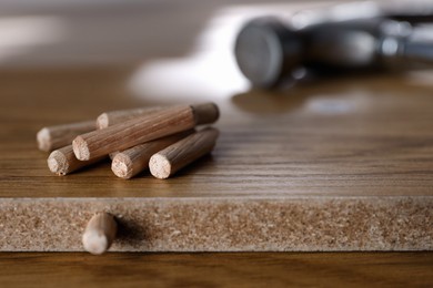 Wooden furniture parts and pile of dowels, closeup. Self-assembly
