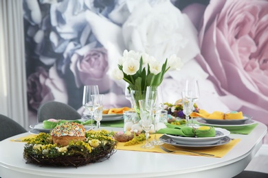 Festive Easter table setting with beautiful white tulips and eggs indoors