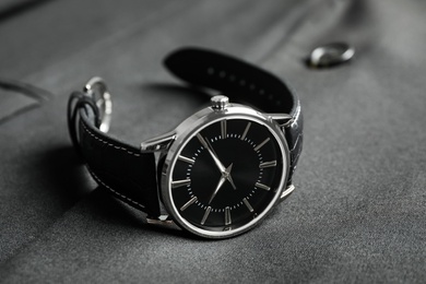 Photo of Luxury wrist watch on black fabric, closeup