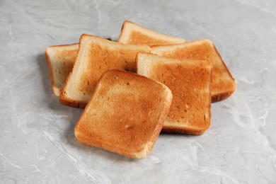 Photo of Slices of delicious toasted bread on gray marble table