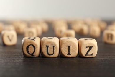 Cubes with word Quiz on wooden table, closeup