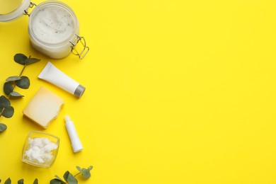 Flat lay composition with beeswax cosmetics on yellow background. Space for text