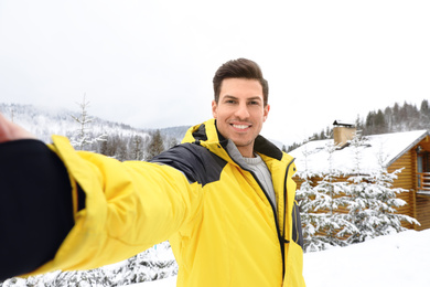 Photo of Happy man taking selfie at resort. Winter vacation
