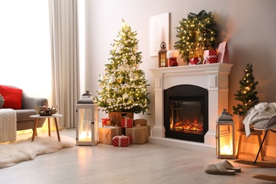 Stylish living room interior with beautiful fireplace, Christmas tree
