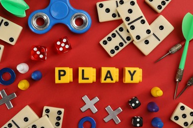 Components of board games and blocks with word Play on red background, flat lay