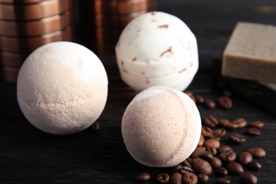 Photo of Bath bombs and coffee beans on black wooden table