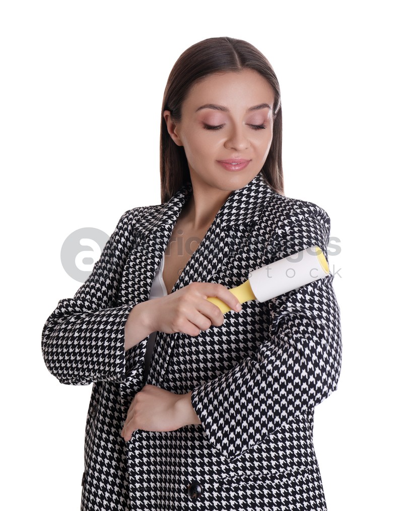 Photo of Young woman cleaning clothes with lint roller on white background