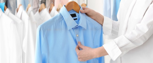 Young woman holding hanger with shirt, banner design. Dry-cleaning service