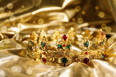 Beautiful ancient crown on golden fabric, closeup. Fantasy item