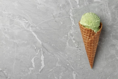 Delicious pistachio ice cream on grey marble table, top view. Space for text