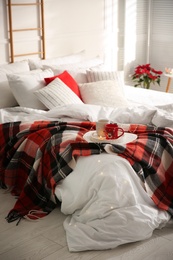 Photo of Christmas bedroom interior with red woolen blanket