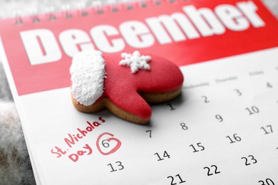Saint Nicholas Day. Calendar with marked date December 06 and glove shape gingerbread cookie, closeup
