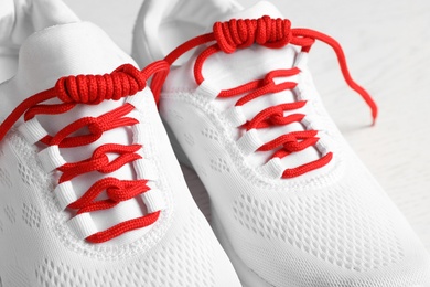 Pair of stylish shoes with red laces on white background, closeup