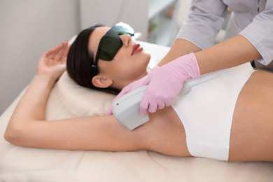 Young woman undergoing laser epilation procedure in beauty salon
