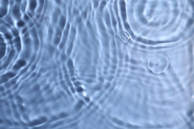 Closeup view of water with rippled surface on blue background