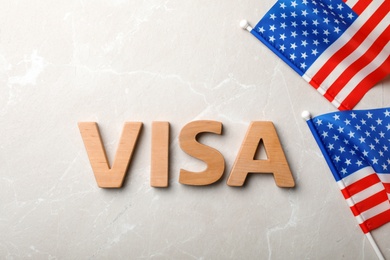 Flat lay composition with word VISA and flags of USA on gray background