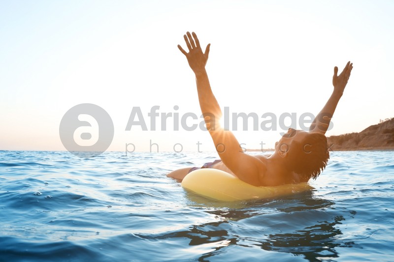Young man with inflatable ring in sea