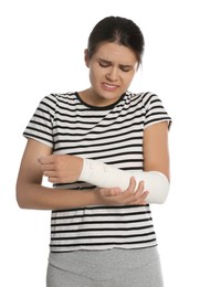 Young woman with arm wrapped in medical bandage on white background