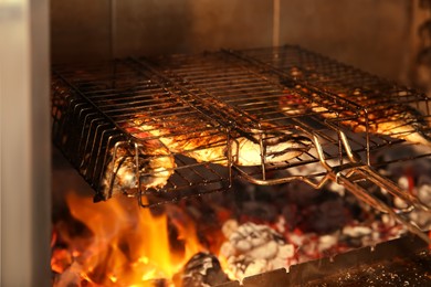 Grilling basket with whole fish in oven, closeup