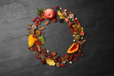 Dried flowers, leaves and berries arranged in shape of wreath on black background, flat lay with space for text. Autumnal aesthetic