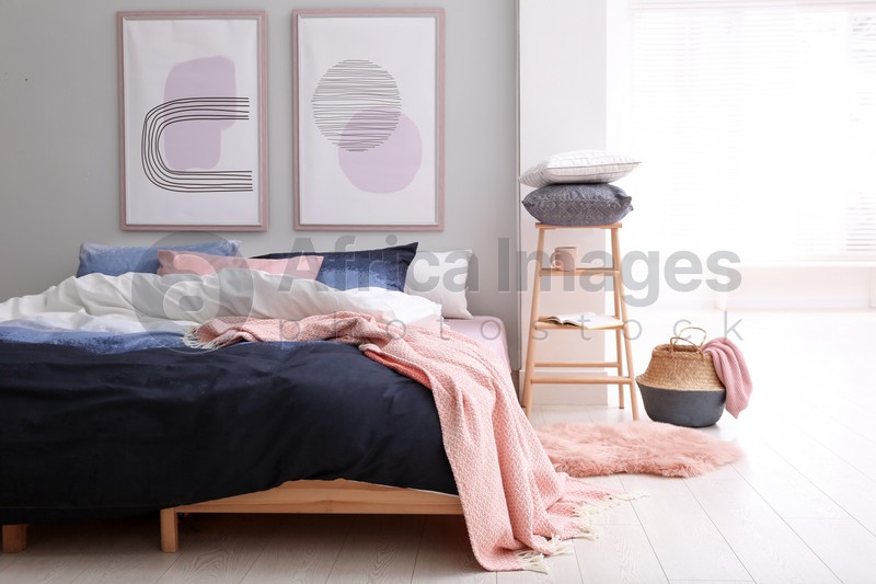 Photo of Comfortable bed with stylish linens in room