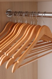 Photo of Set of clothes hangers on wardrobe rail, closeup