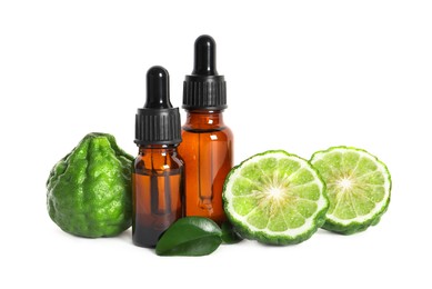 Bottles of essential oil, fresh bergamot fruits and leaves on white background