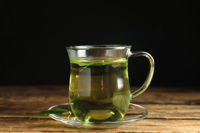 Cup of aromatic green tea on wooden table
