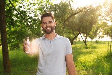 Man with insect repellent spray in park. Tick bites prevention